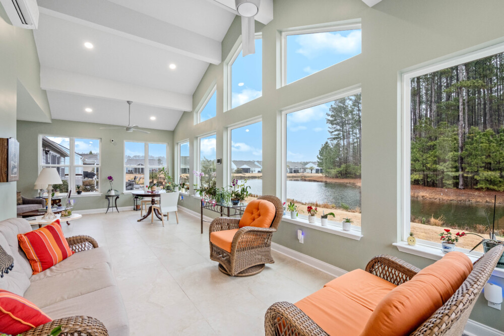 Bright custom sunroom with floor-to-ceiling windows, designed as a comfortable indoor-outdoor living space filled with natural light