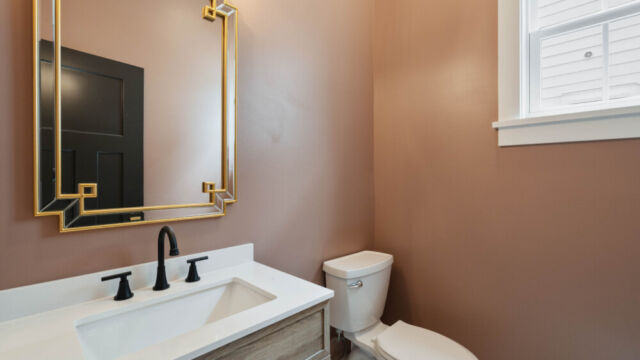 Modern powder room with vanity, mirror, and sleek fixtures.