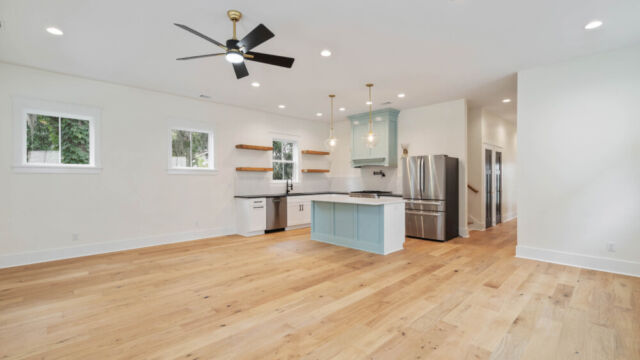 Designer kitchen with wood open shelving, state-of-the-art appliances, and vintage-inspired lighting.