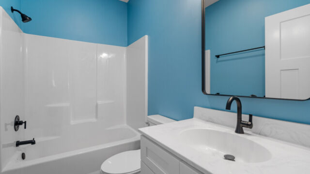 Spacious bathroom featuring a bathtub, vanity, and sleek contemporary fixtures.