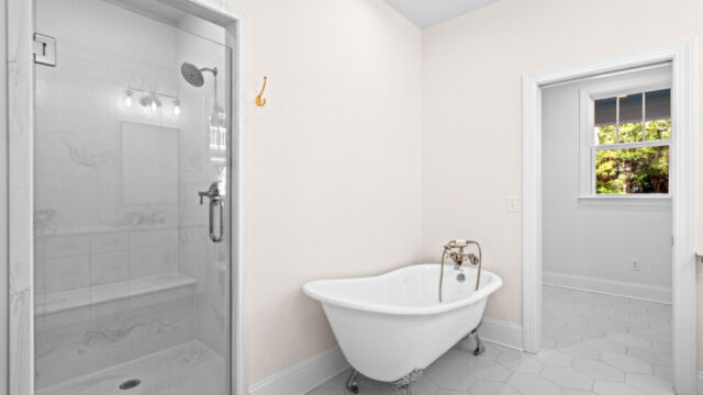 Primary bathroom featuring a classic clawfoot tub, vanity, and elegant finishes.