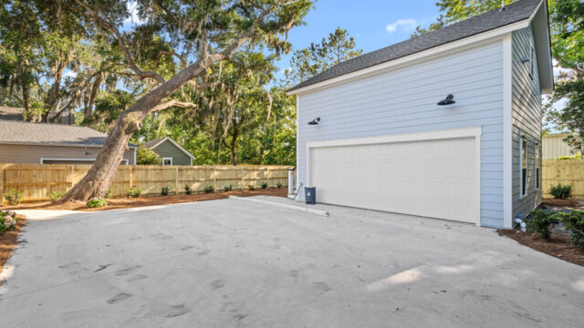 Spacious house exterior highlighting materials, windows, and surrounding greenery.