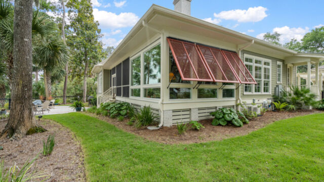 Sunroom addition to a home, featuring large windows and stylish architectural details.