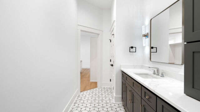 Bright and spacious bathroom with tile floors, countertop sinks, and modern accents.