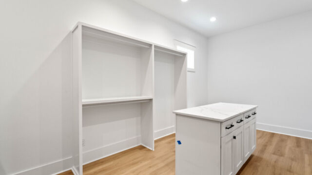 Spacious primary closet featuring built-in storage and laundry area.