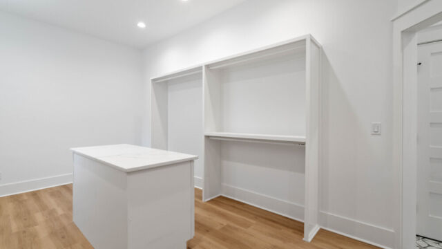 Spacious primary closet featuring built-in storage and laundry area.