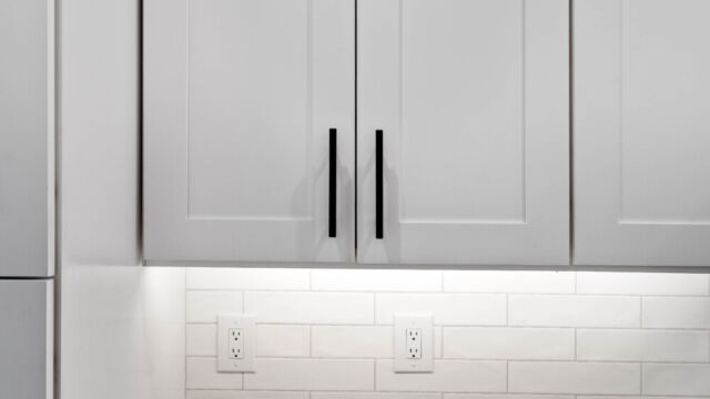 Contemporary open kitchen with central island, cabinetry, and high-end finishes.