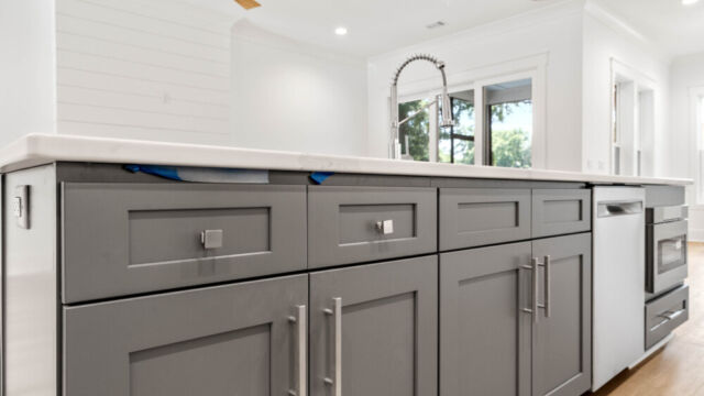 Contemporary open kitchen with central island, cabinetry, and high-end finishes.