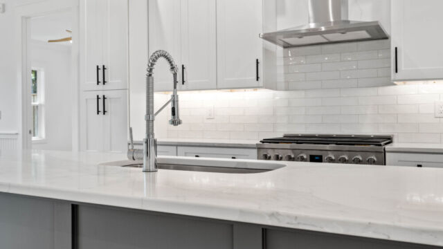 Contemporary open kitchen with central island, cabinetry, and high-end finishes.