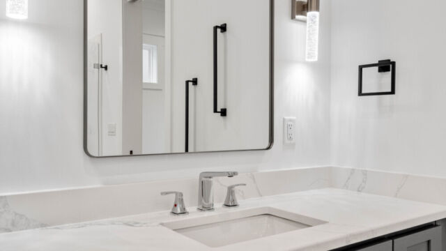 Spacious primary bathroom with tile floors, double vanity, and modern fixtures.