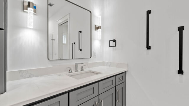 Spacious primary bathroom with tile floors, double vanity, and modern fixtures.