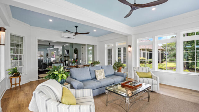 Sunroom addition to a home, featuring large windows and stylish architectural details.