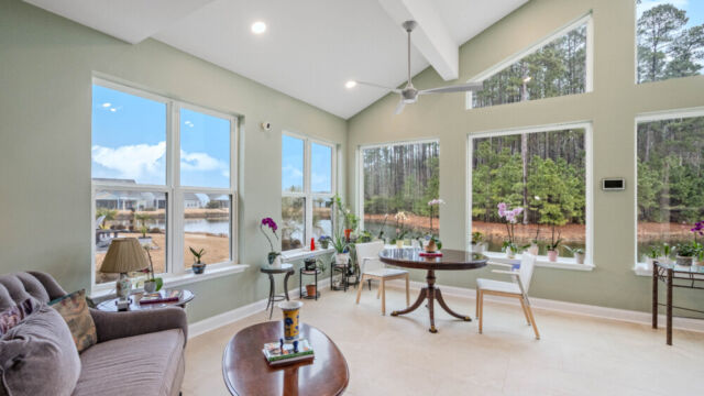 Bright custom sunroom with floor-to-ceiling windows, designed as a comfortable indoor-outdoor living space filled with natural light
