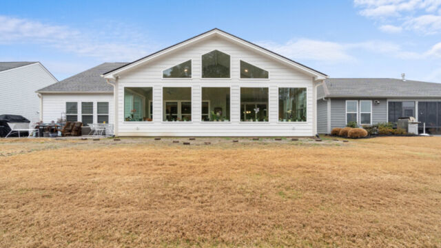 Bright custom sunroom with floor-to-ceiling windows, designed as a comfortable indoor-outdoor living space filled with natural light