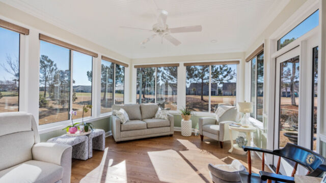 Bright custom sunroom with floor-to-ceiling windows, designed as a comfortable indoor-outdoor living space filled with natural light