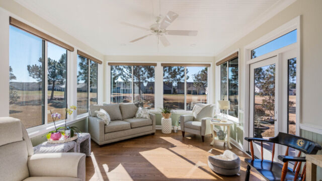 Bright custom sunroom with floor-to-ceiling windows, designed as a comfortable indoor-outdoor living space filled with natural light