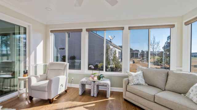 Bright custom sunroom with floor-to-ceiling windows, designed as a comfortable indoor-outdoor living space filled with natural light