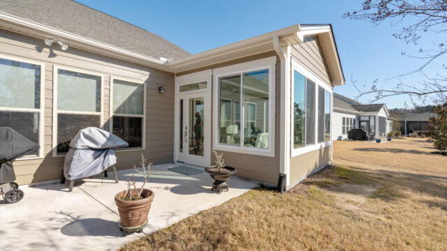 Bright custom sunroom with floor-to-ceiling windows, designed as a comfortable indoor-outdoor living space filled with natural light