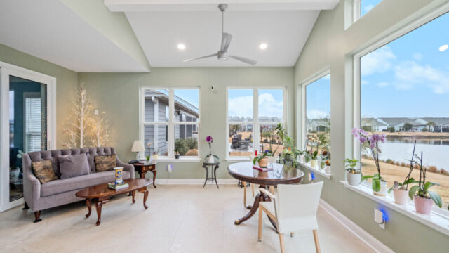 Bright custom sunroom with floor-to-ceiling windows, designed as a comfortable indoor-outdoor living space filled with natural light