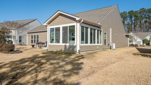 Bright custom sunroom with floor-to-ceiling windows, designed as a comfortable indoor-outdoor living space filled with natural light