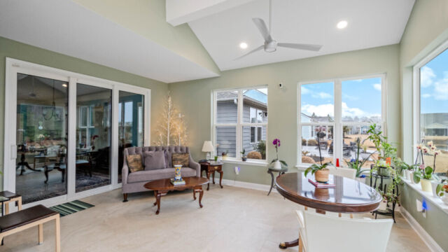 Bright custom sunroom with floor-to-ceiling windows, designed as a comfortable indoor-outdoor living space filled with natural light