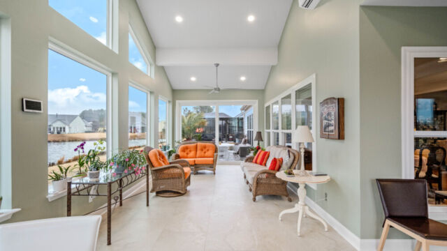 Bright custom sunroom with floor-to-ceiling windows, designed as a comfortable indoor-outdoor living space filled with natural light