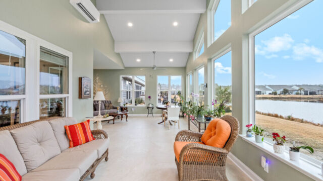 Bright custom sunroom with floor-to-ceiling windows, designed as a comfortable indoor-outdoor living space filled with natural light