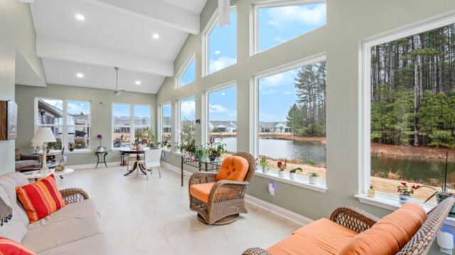 Bright custom sunroom with floor-to-ceiling windows, designed as a comfortable indoor-outdoor living space filled with natural light