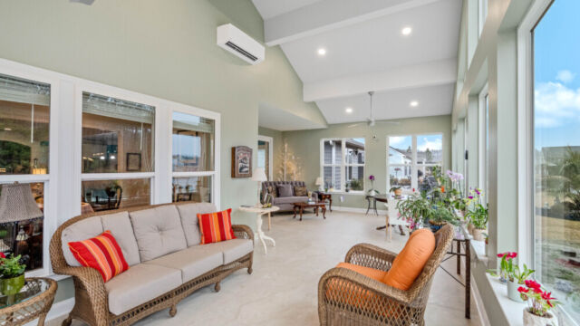 Bright custom sunroom with floor-to-ceiling windows, designed as a comfortable indoor-outdoor living space filled with natural light