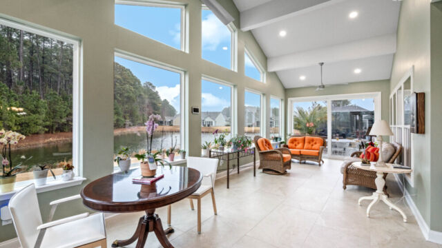 Bright custom sunroom with floor-to-ceiling windows, designed as a comfortable indoor-outdoor living space filled with natural light