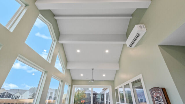 Bright custom sunroom with floor-to-ceiling windows, designed as a comfortable indoor-outdoor living space filled with natural light